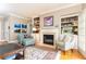 Cozy living room showcasing a fireplace, built-in bookshelves, hardwood floors and sophisticated decor at 211 Colonial Homes Nw Dr # 2508, Atlanta, GA 30309