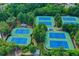Aerial view featuring multiple tennis courts surrounded by green trees and well manicured grounds at 4240 Hastings Dr, Cumming, GA 30041