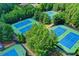 Aerial view featuring multiple tennis courts surrounded by green trees and well manicured grounds at 4240 Hastings Dr, Cumming, GA 30041