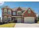 Elegant brick home showcasing a well-manicured lawn, mature landscaping, and a spacious three-car garage at 4240 Hastings Dr, Cumming, GA 30041