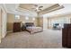 Spacious bedroom featuring a tray ceiling, carpeted floor, and a cozy nook with a computer desk at 4240 Hastings Dr, Cumming, GA 30041