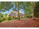 Secluded backyard featuring mature trees, lush lawn, and an outdoor dining space at 378 Rhodes House Dr, Suwanee, GA 30024