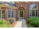 Close-up of a brick home's front door with an arched entrance and detailed landscaping at 378 Rhodes House Dr, Suwanee, GA 30024