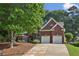 Charming brick home with well-manicured landscaping, a two-car garage, and mature trees at 378 Rhodes House Dr, Suwanee, GA 30024