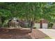 Beautiful brick home with a two-car garage, mature trees and landscaping at 378 Rhodes House Dr, Suwanee, GA 30024