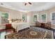 Spacious main bedroom with tray ceiling, sitting area, and hardwood floors at 378 Rhodes House Dr, Suwanee, GA 30024