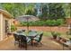 Outdoor patio area with a dining table, chairs, and a landscaped backyard at 378 Rhodes House Dr, Suwanee, GA 30024