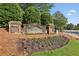 Community entrance sign with stone accents and manicured landscaping at 378 Rhodes House Dr, Suwanee, GA 30024