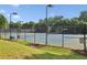 A beautiful tennis court with pristine fencing, professional lighting and manicured landscaping at 378 Rhodes House Dr, Suwanee, GA 30024