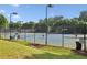 Outdoor tennis courts with surrounding fencing and lush landscaping at 378 Rhodes House Dr, Suwanee, GA 30024