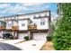 Stylish townhome featuring a private balcony, a two-car garage, and lush landscaping at 3786 Alstead Manor Way, Suwanee, GA 30024