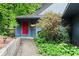 Charming home featuring a vibrant red front door, complemented by stone walkway and landscaped surroundings at 3863 Dundee Ne Dr, Roswell, GA 30075