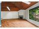 Bright living room with wood floors, fireplace, skylight, large window with serene views of the lake and trees at 3863 Dundee Ne Dr, Roswell, GA 30075