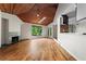 Sun-drenched living room with wood floors, fireplace, skylight, and an opening to the kitchen area with natural views at 3863 Dundee Ne Dr, Roswell, GA 30075