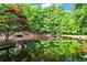 Still pond reflecting the surrounding lush trees and sky, creating a peaceful setting at 3863 Dundee Ne Dr, Roswell, GA 30075