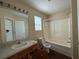 This bathroom features a shower-tub, wood-style flooring, and a sink with a wood cabinet at 5280 Tussahaw Xing, Mcdonough, GA 30252