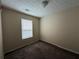 A cozy bedroom with neutral walls, carpeted floors, and a window providing natural light at 5280 Tussahaw Xing, Mcdonough, GA 30252