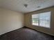Bright bedroom with soft carpeting, large window, and neutral colored walls at 5280 Tussahaw Xing, Mcdonough, GA 30252