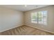 This bedroom has neutral walls and carpet with a window letting in lots of light at 5280 Tussahaw Xing, Mcdonough, GA 30252