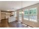 Open dining area connected to a bright kitchen with white cabinets and modern appliances and an adjoining door at 5280 Tussahaw Xing, Mcdonough, GA 30252