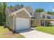 Side view of a two-story home showcasing the vinyl siding, brick accents, attached garage, and well-kept lawn at 5280 Tussahaw Xing, Mcdonough, GA 30252