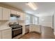 Modern kitchen with stainless steel appliances and white cabinets overlooking dining area at 5280 Tussahaw Xing, Mcdonough, GA 30252