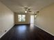 Open living room featuring dark hardwood floors, neutral walls, and a large window offering natural light at 5280 Tussahaw Xing, Mcdonough, GA 30252