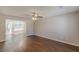 Bright living room with modern ceiling fan, wood-look floors, neutral paint, and lots of natural light at 5280 Tussahaw Xing, Mcdonough, GA 30252