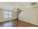 Inviting living room with modern ceiling fan, wood-look floors, neutral paint, stairs to upper floor, and natural light at 5280 Tussahaw Xing, Mcdonough, GA 30252