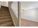 Carpeted staircase leading to upper level, adjacent to a well-lit living space at 5280 Tussahaw Xing, Mcdonough, GA 30252