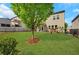 Spacious backyard with lush green grass, fence, a small tree, and a playhouse at 5751 Green Arbor Way, Sugar Hill, GA 30518