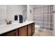 Bathroom with double sink vanity, dark wood cabinets, granite countertop, and shower with curtain at 5751 Green Arbor Way, Sugar Hill, GA 30518