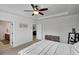 A neutral colored bedroom features a tray ceiling, a bed, and a view to the Primary bath at 5751 Green Arbor Way, Sugar Hill, GA 30518