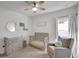 Cozy Bedroom with crib, dresser, gliding chair, neutral colors, and ceiling fan at 5751 Green Arbor Way, Sugar Hill, GA 30518