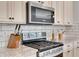 Close-up of stainless steel appliances, granite countertops, and white subway tile backsplash in a modern kitchen at 5751 Green Arbor Way, Sugar Hill, GA 30518