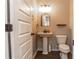 Half bath with pedestal sink, toilet, and decorative mirror and wallpaper at 1024 Burke St # 56, Lawrenceville, GA 30046