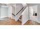 Hallway with hardwood floors, carpeted stairs and white trim at 174 Riverwood Dr, Dallas, GA 30157