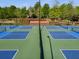 View of blue community pickleball courts with white trim, nets, and black fencing at 174 Riverwood Dr, Dallas, GA 30157
