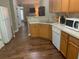 View of a kitchen with wood cabinetry, white appliances, and a sink with an open view of the living area at 2253 Dillard Xing, Tucker, GA 30084