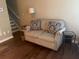 Cozy living room features a loveseat with decorative pillows, complemented by side tables and hardwood flooring at 2253 Dillard Xing, Tucker, GA 30084