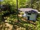 View of the house's rear exterior with a small patio surrounded by trees with a lush, green backyard at 2704 Terratim Ln, Decatur, GA 30034