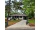 Charming single-story home with a long driveway and lush green lawn and beautiful trees at 2704 Terratim Ln, Decatur, GA 30034