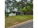 A quaint single-story home with a white painted brick exterior sits atop a gently sloping, grassy front yard at 2704 Terratim Ln, Decatur, GA 30034