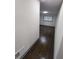 Hallway leading to the bedroom with hardwood flooring, baseboard trim, and window with coverings at 2704 Terratim Ln, Decatur, GA 30034
