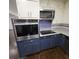 This kitchen features stainless steel appliances, granite countertops and blue cabinets at 2704 Terratim Ln, Decatur, GA 30034
