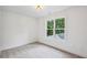 Bright bedroom with neutral carpet, white walls, trim, and a large window offering natural light at 1347 Midlawn Dr, Decatur, GA 30032