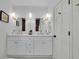 Bathroom with double sinks, white cabinets, dark tile wall, gold fixtures and black hardware at 1430 Dallas Circle Sw, Marietta, GA 30064