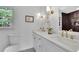 Bathroom with double sinks, white cabinets, dark tile wall, and gold fixtures at 1430 Dallas Circle Sw, Marietta, GA 30064