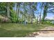 Wide shot of the property's expansive backyard with lush lawn, greenery, and shed at 2111 Holly Hill Dr, Decatur, GA 30032