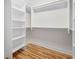 Walk-in closet featuring hardwood floors, white walls, and shelving for ample storage and organization at 2111 Holly Hill Dr, Decatur, GA 30032